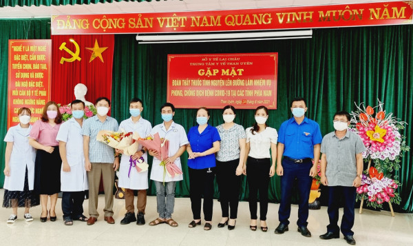 (Đại diện Thường trực Huyện ủy, HĐND - UBND, UBMTTQ, các cơ quan, các tổ chức chính trị - xã hội huyện và tập thể lãnh đạo Trung tâm Y tế huyện tặng hoa động viên các thầy thuốc tình nguyện)